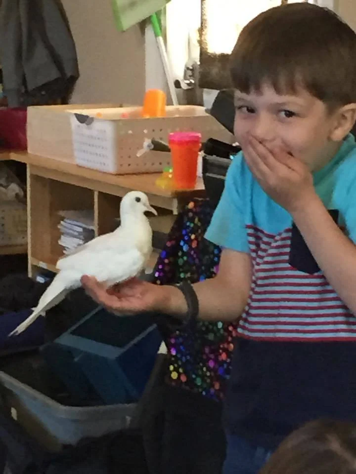 child holding bird after magic show with a huge smile!