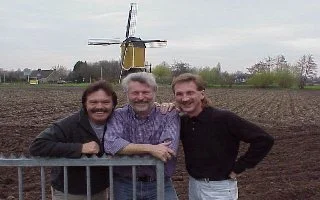 Magician Rick Moore, Road Rage Rudy and Magician Rodney Kelley posing in front of a windmill in Holland