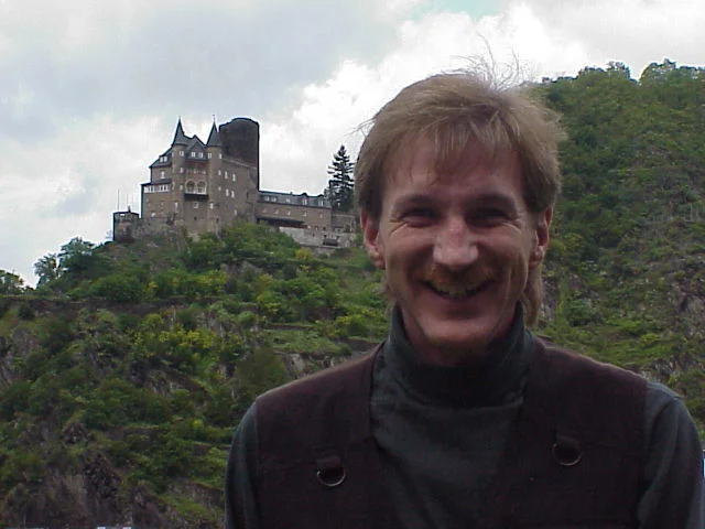 Magician Rodney Kelley in Germany posing with a huge castle behind him